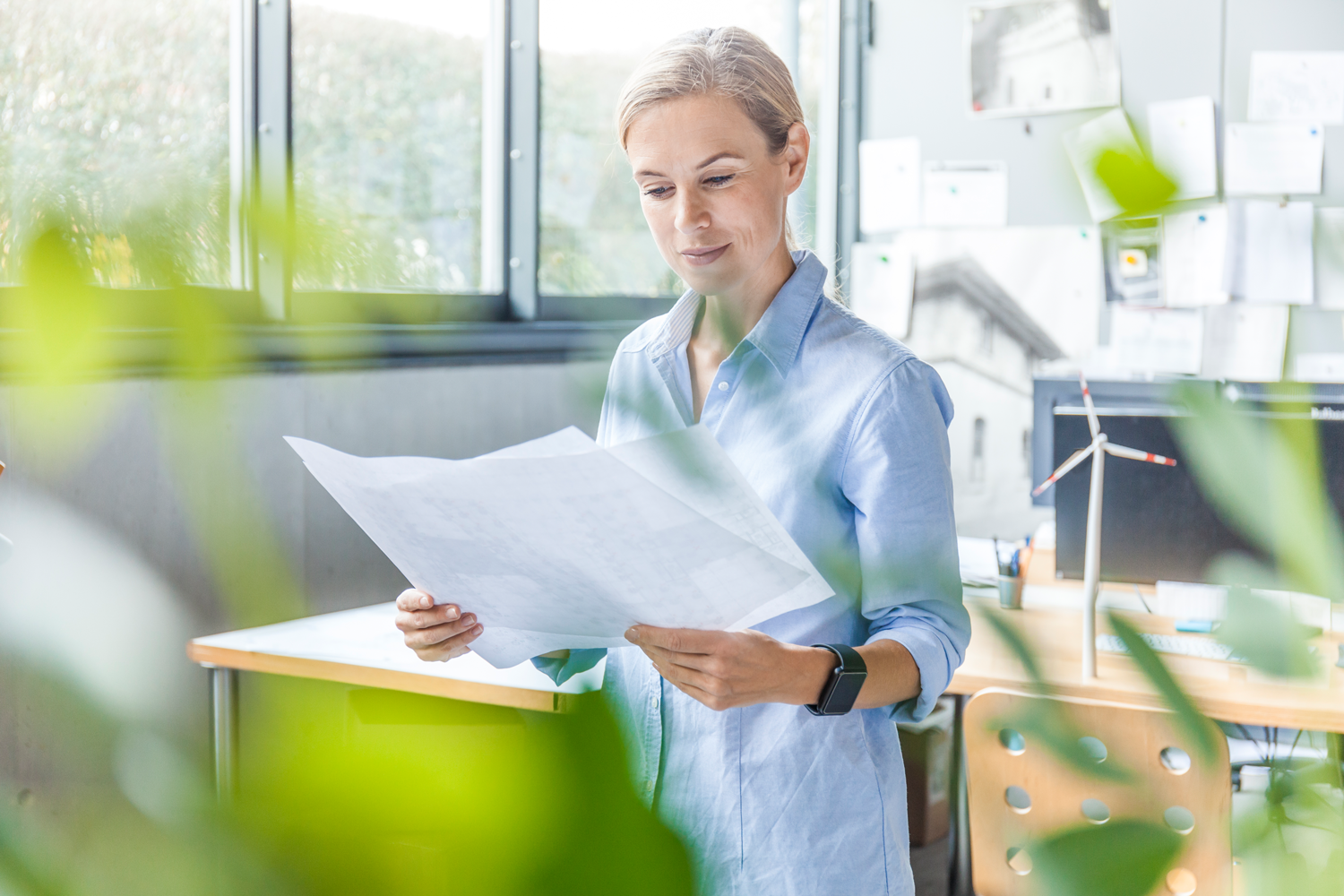 woman in office working on plan with wind turbine 2022 03 08 01 28 39 utc woman in office working on plan with wind turbine 2022 03 08 01 28 39 utc